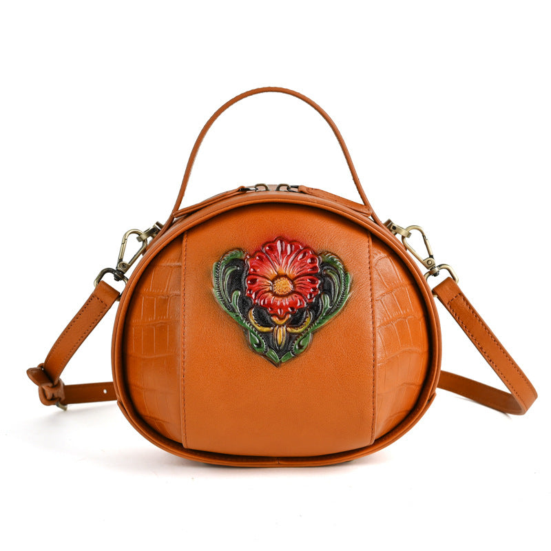Front view of the vintage brown embossed round crossbody bag