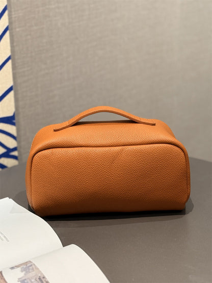 Side angle of orange-brown pouch showing its zipper and depth