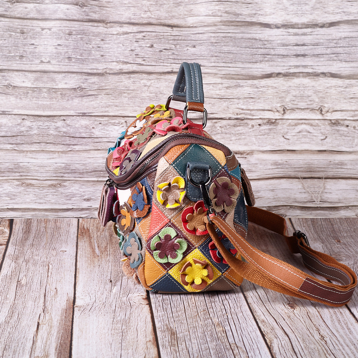 Close view of floral appliques and patchwork panels on the leather bag