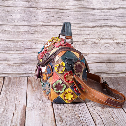 Close view of floral appliques and patchwork panels on the leather bag