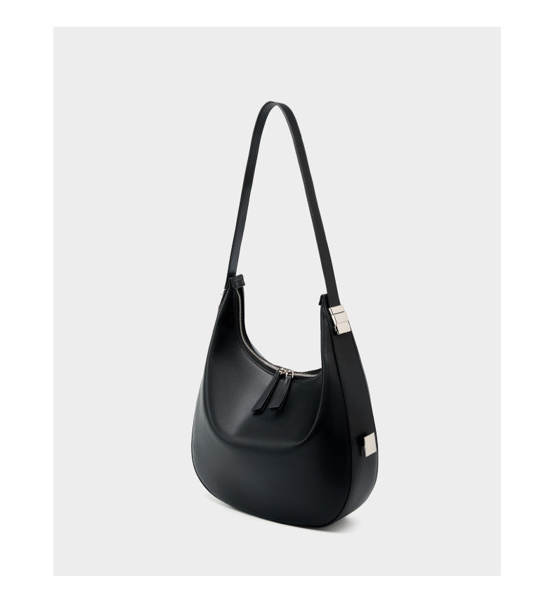 Three-quarter view of the black cowhide leather crescent hobo bag with the strap raised, showing the top zip closure