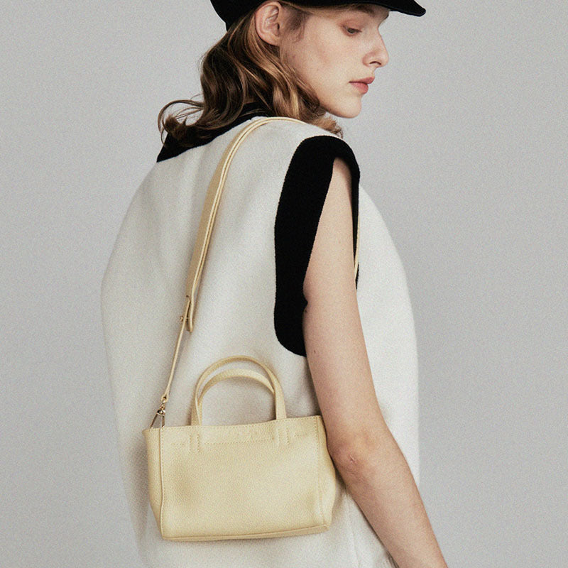Model carrying the mini tote over the shoulder