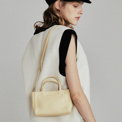 Model carrying the mini tote over the shoulder
