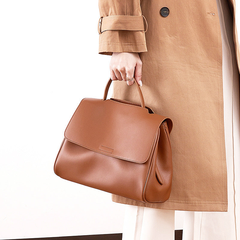 Brown cowhide leather top-handle bag carried by top handle