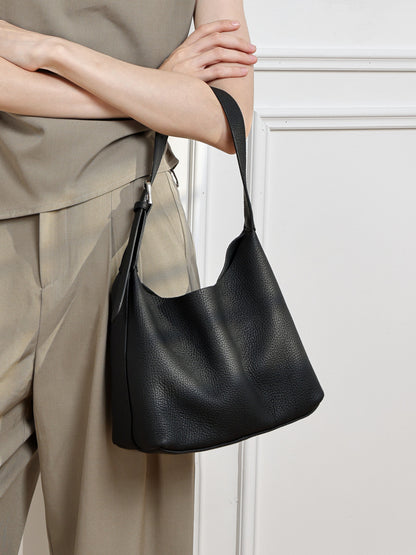 Black pebbled leather hobo bag styled with a beige outfit