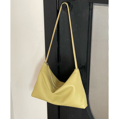 Yellow zip-top hobo bag hanging against a dark door