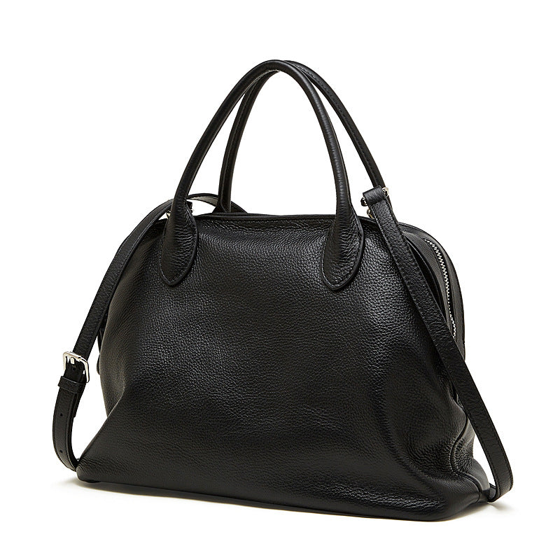 Front view of a black pebbled cowhide leather bowling tote bag on a white background