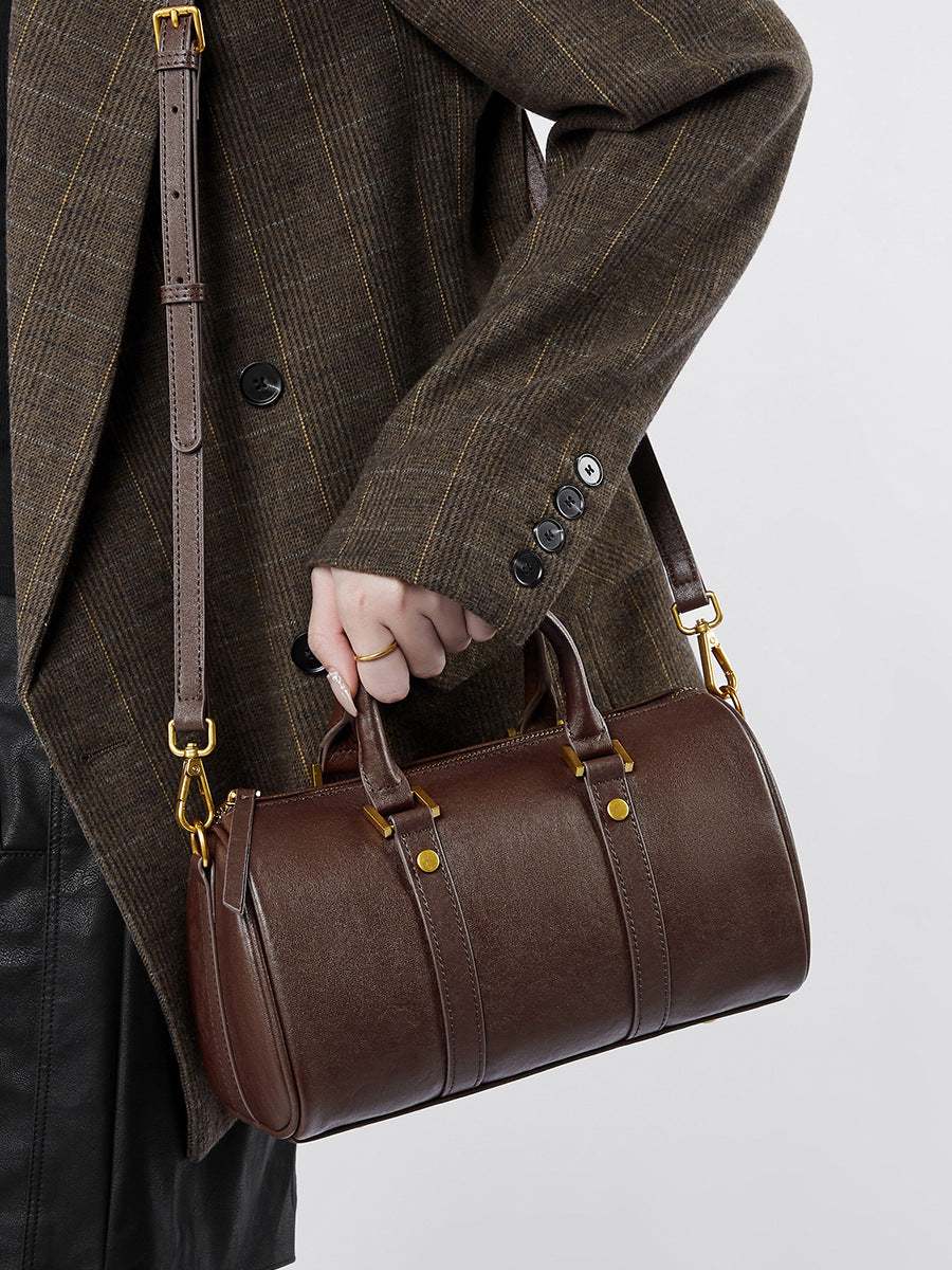 Dark brown Boston bag worn crossbody with adjustable shoulder strap