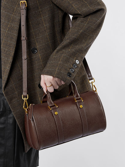 Dark brown Boston bag worn crossbody with adjustable shoulder strap