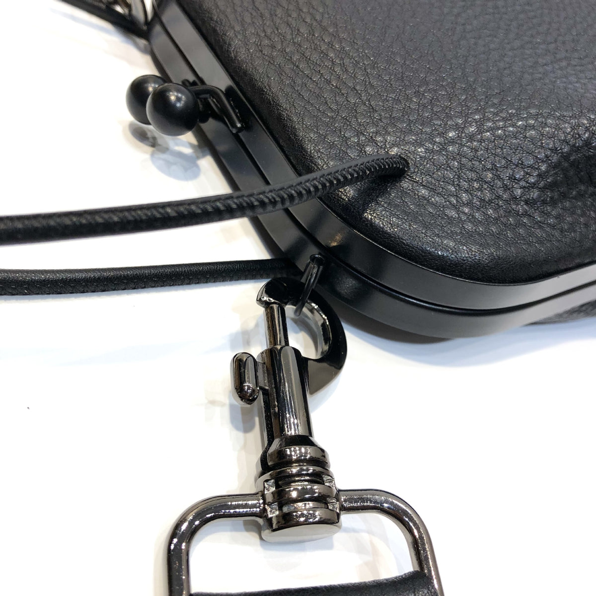 Close-up of black leather grain and dark frame hardware