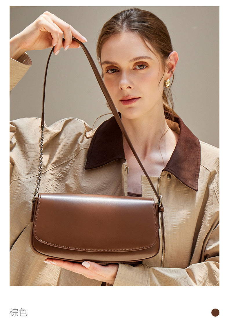 Close-up of the brown baguette bag showing magnetic flap closure and leather- chain strap