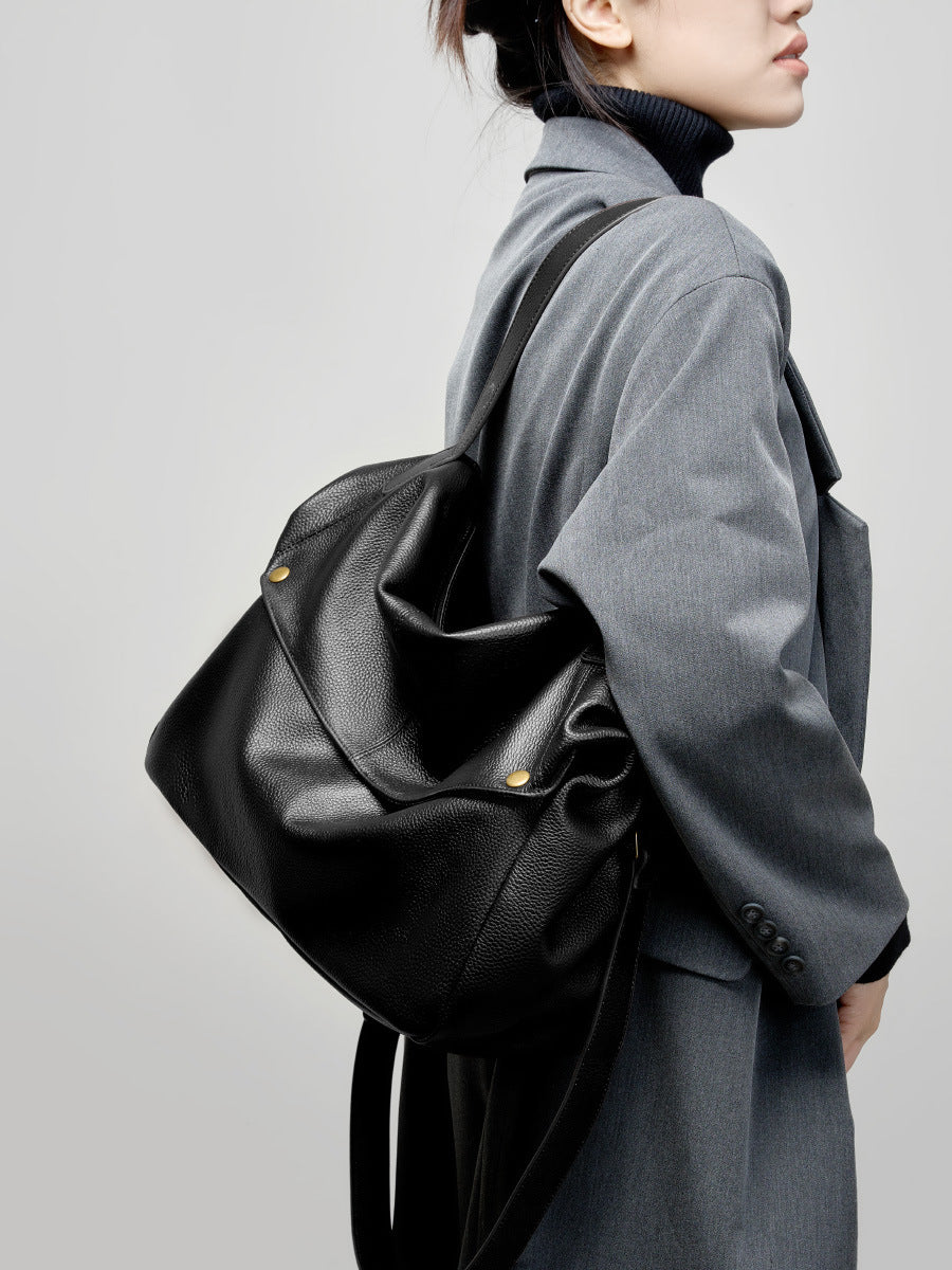 Black cowhide leather tote bag styled with a gray wool coat