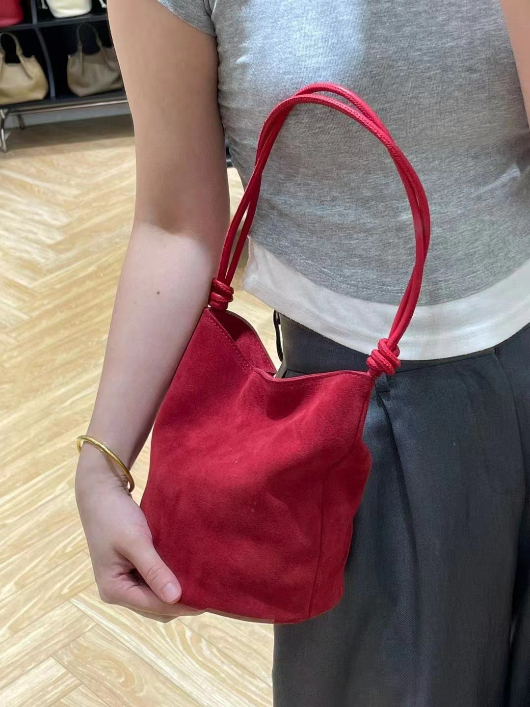Red shoulder bag shown against a casual outfit
