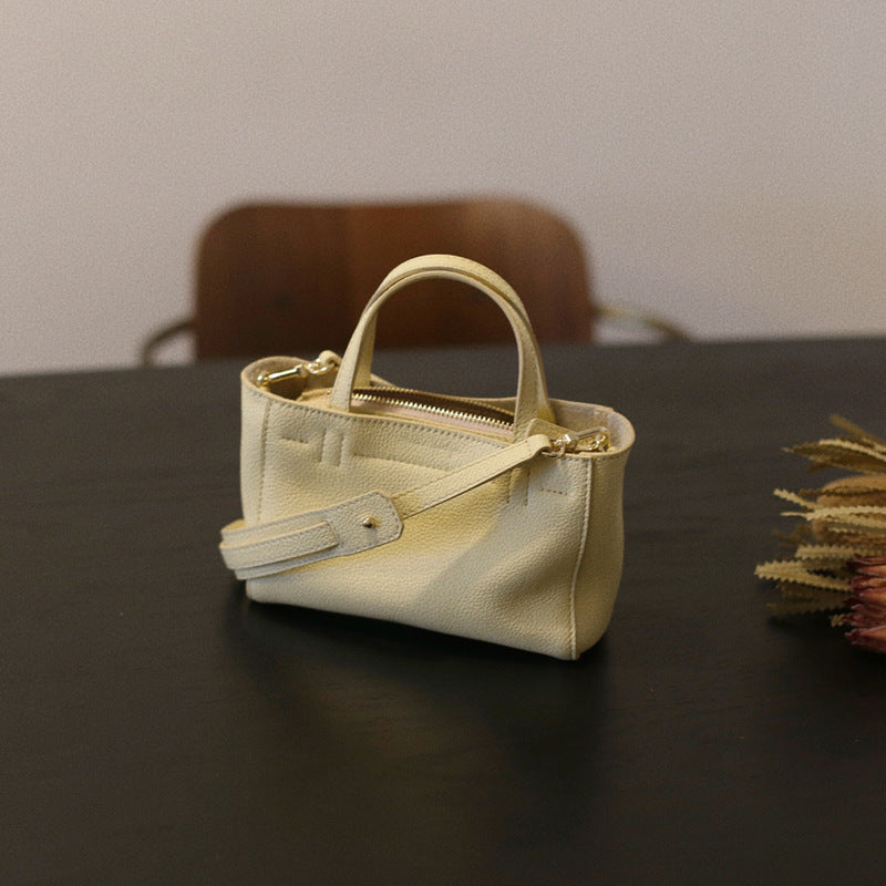 Chick yellow mini tote showing its zip top and detachable strap