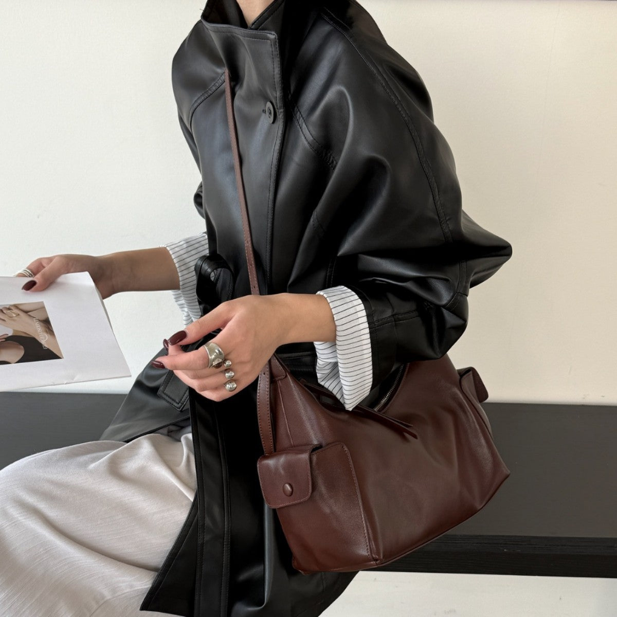 Beige shoulder bag displayed with its strap held up