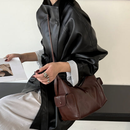 Beige shoulder bag displayed with its strap held up