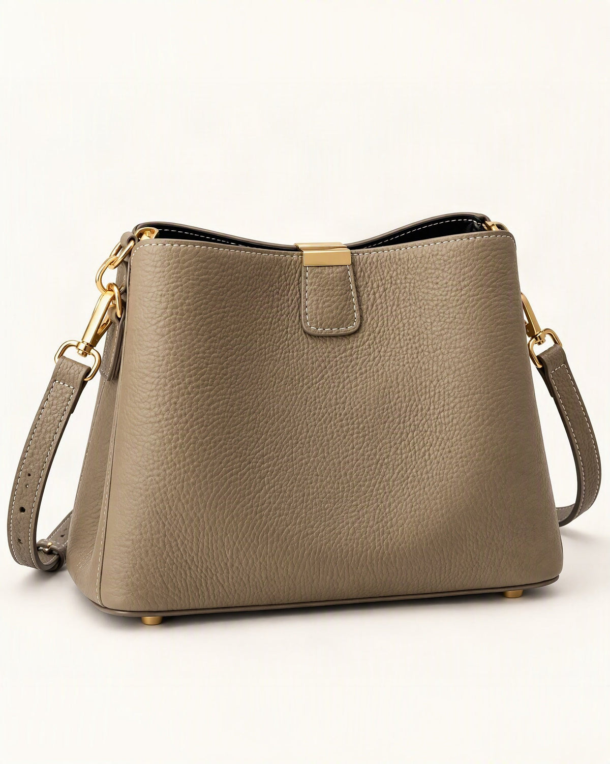 Cowhide Leather Crescent Bucket Bag — front three-quarter view on a warm white background