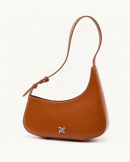 Cowhide Leather Crescent Shoulder Bag — front three-quarter view on a warm white background