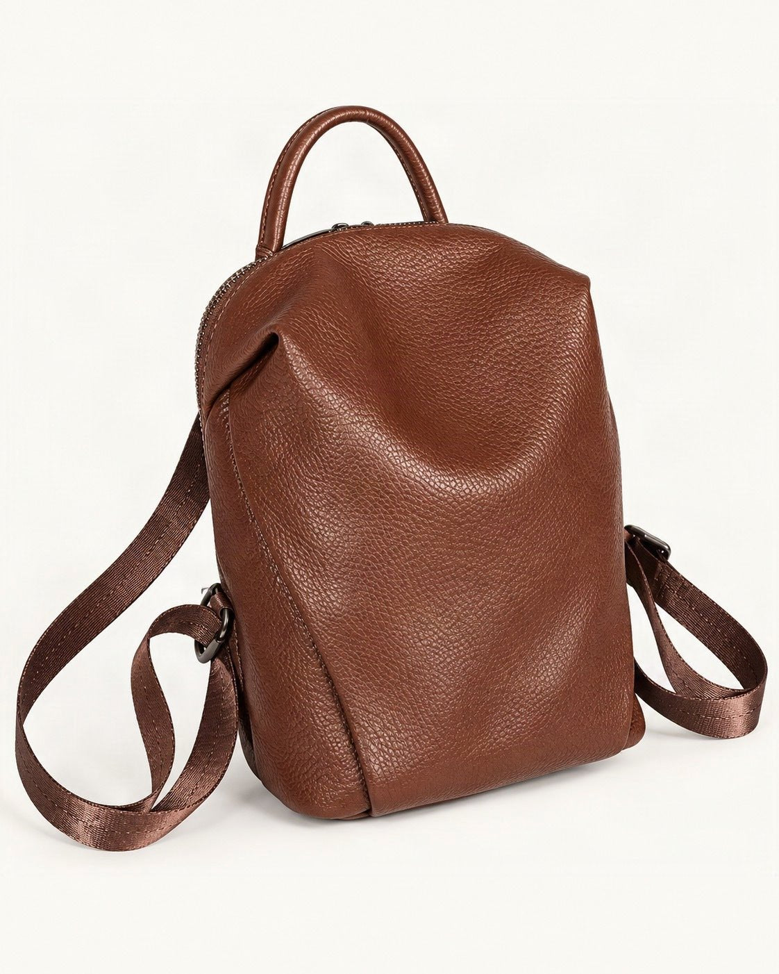 Top-Grain Cowhide Mini Backpack — front three-quarter view on a warm white background