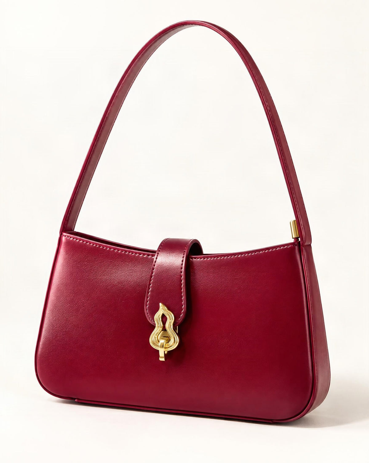 Cowhide Leather Small Shoulder Bag with Gourd Lock Clasp — front three-quarter view on a warm white background