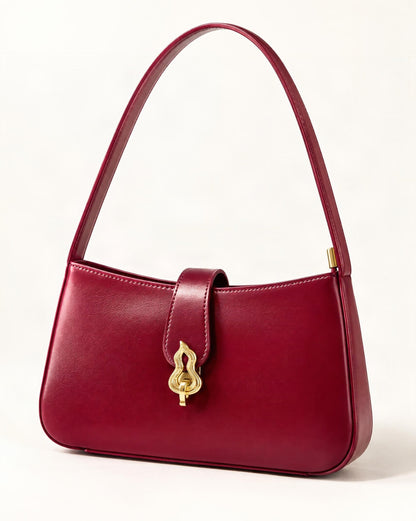 Cowhide Leather Small Shoulder Bag with Gourd Lock Clasp — front three-quarter view on a warm white background
