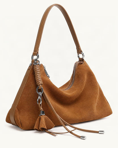 Nubuck Cowhide Underarm Tote Bag with Tassel — front three-quarter view on a warm white background