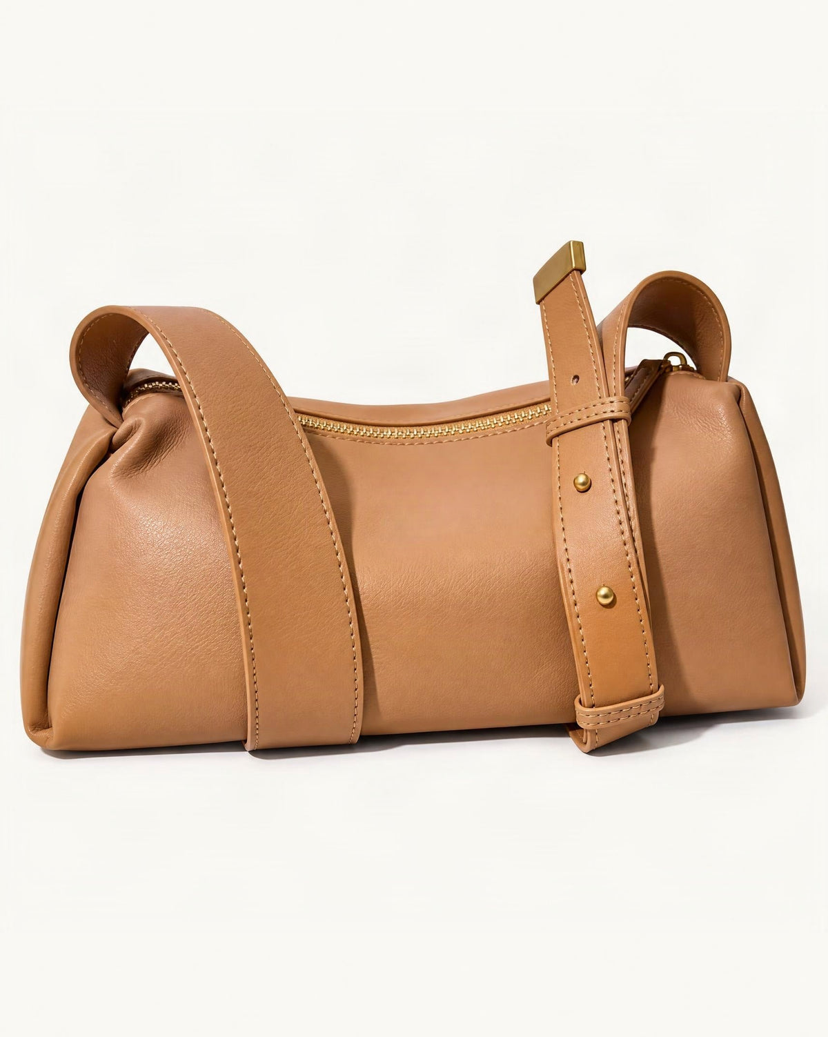 Cowhide Soft Pillow Crossbody Bag with Adjustable Wide Strap — front three-quarter view on a warm white background