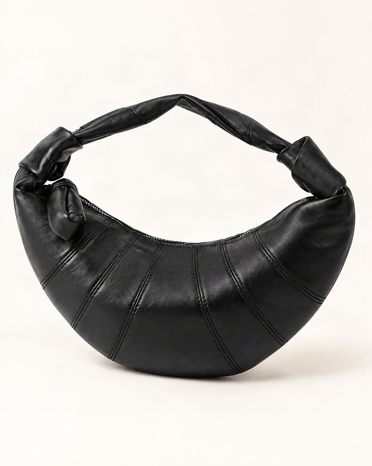 Lambskin Crescent Crossbody Bag with Knotted Strap — front three-quarter view on a warm white background