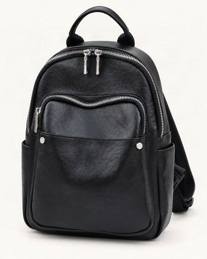 Top-Grain Cowhide Small Backpack — front three-quarter view on a warm white background