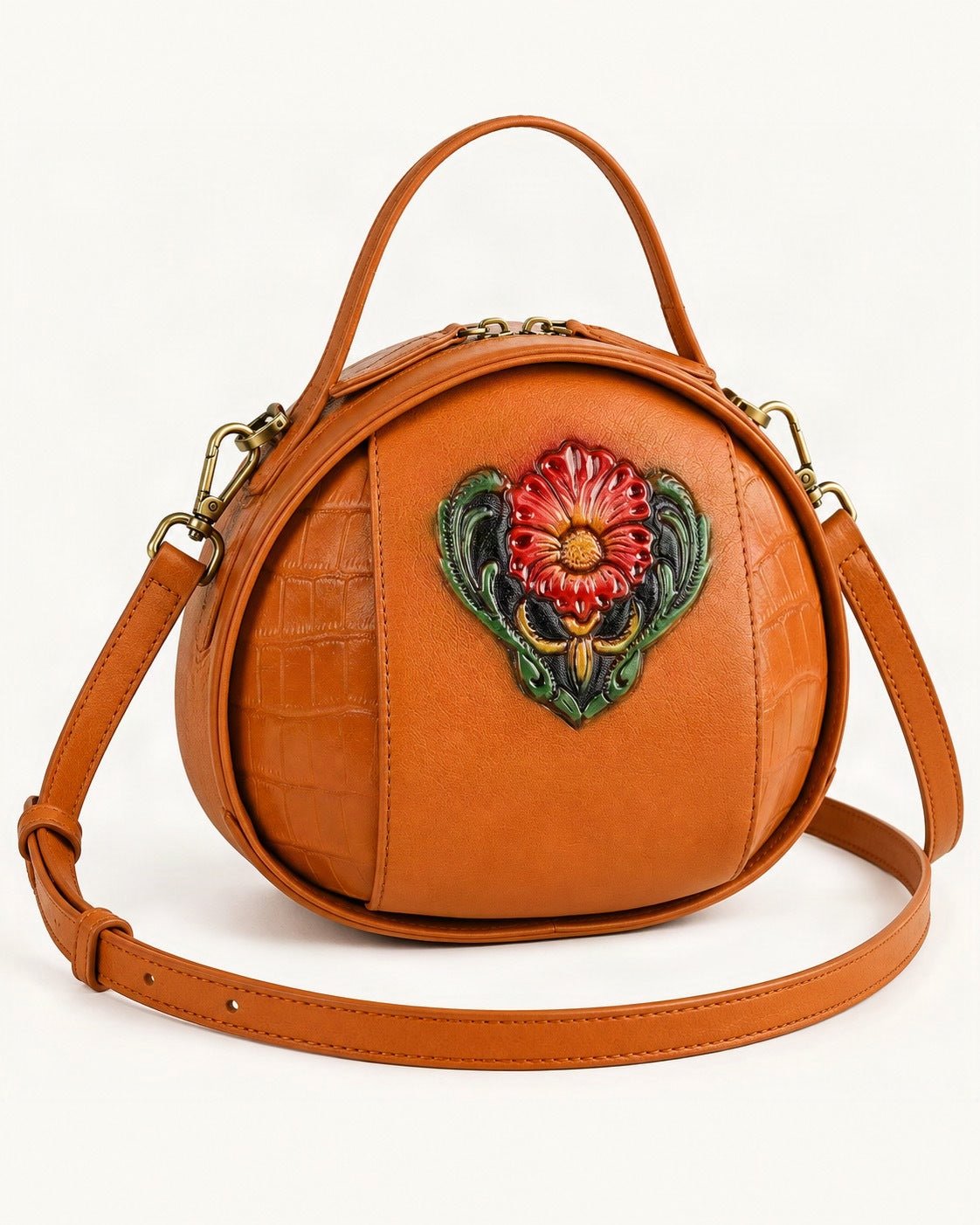 Cowhide Embossed Round Crossbody Bag — front three-quarter view on a warm white background