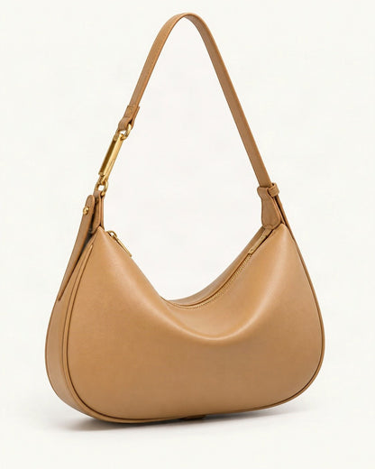 Cowhide Crescent Underarm Bag with X Buckle — front three-quarter view on a warm white background