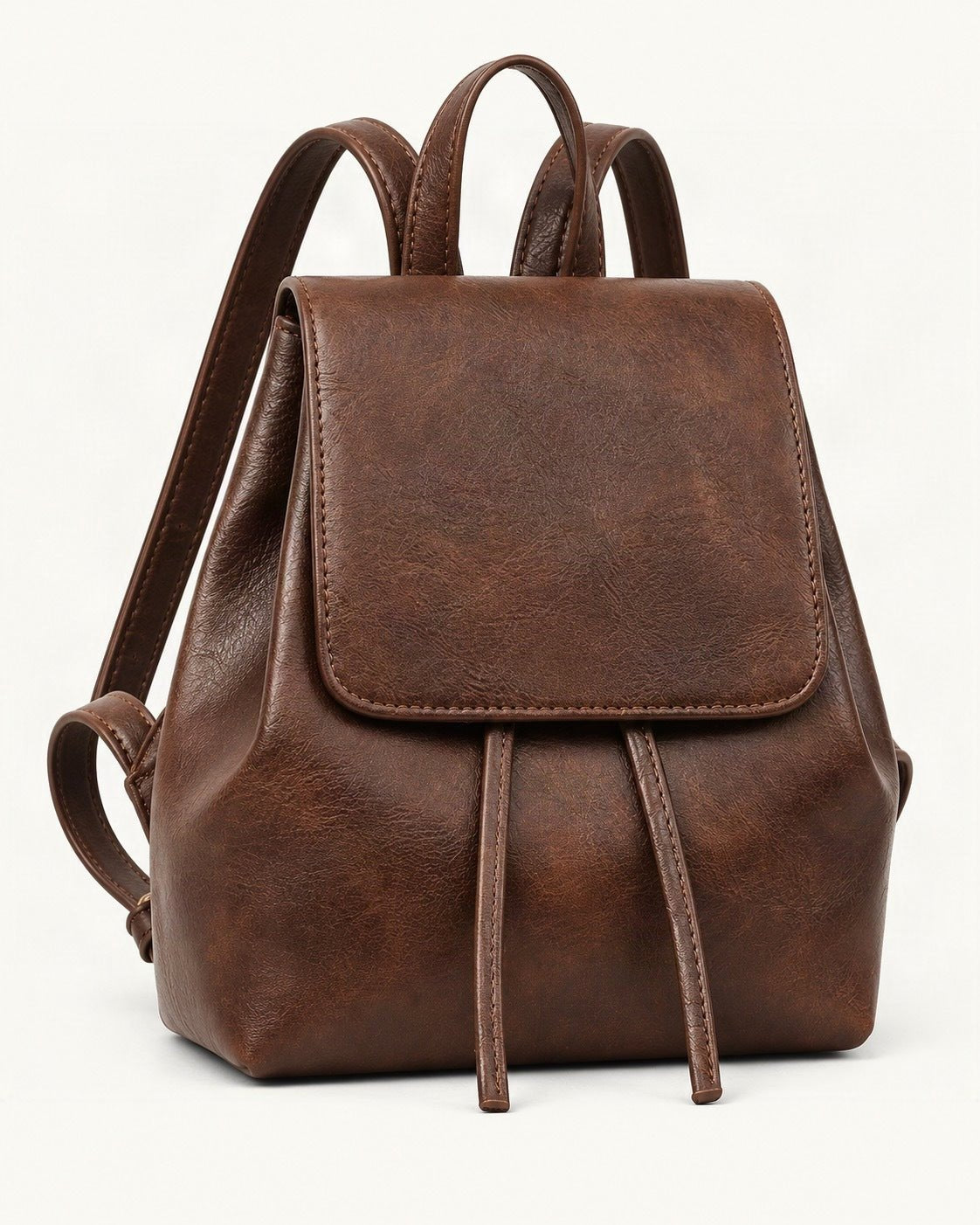 Split Cowhide Mini Backpack — front three-quarter view on a warm white background