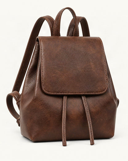 Split Cowhide Mini Backpack — front three-quarter view on a warm white background