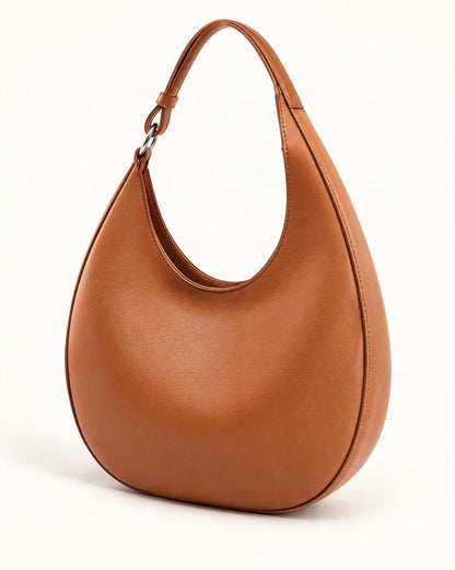 Cowhide Leather Crescent Hobo Bag — front three-quarter view on a warm white background