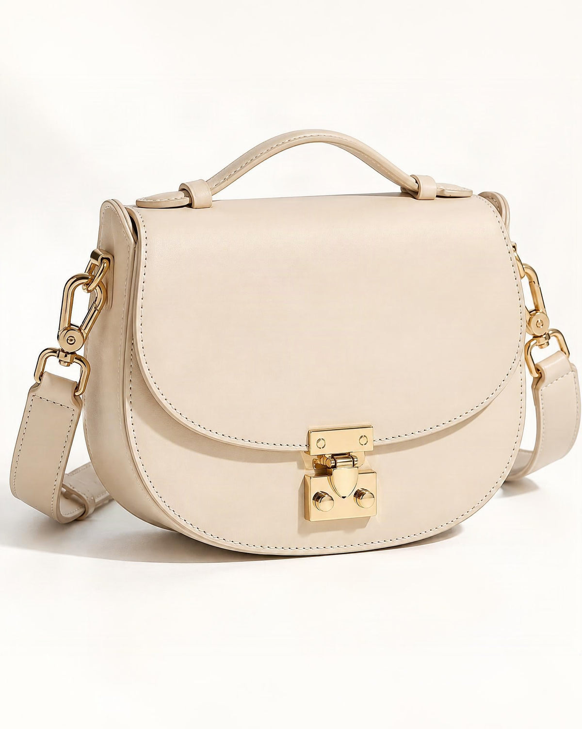 Cowhide Leather Mini Saddle Crossbody Bag with Push Lock — front three-quarter view on a warm white background