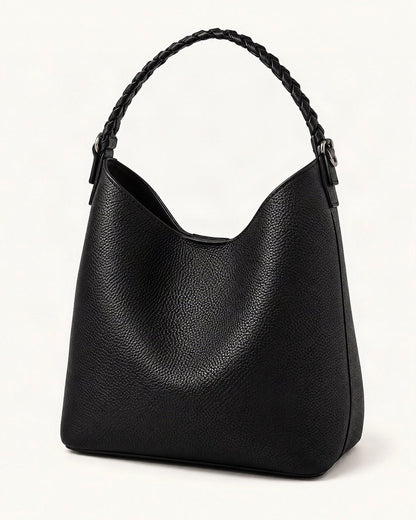 Cowhide Leather Bucket Bag Braided Handle — front three-quarter view on a warm white background