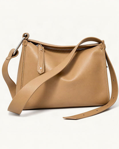 Cowhide Leather Pillow Crossbody Bag — front three-quarter view on a warm white background