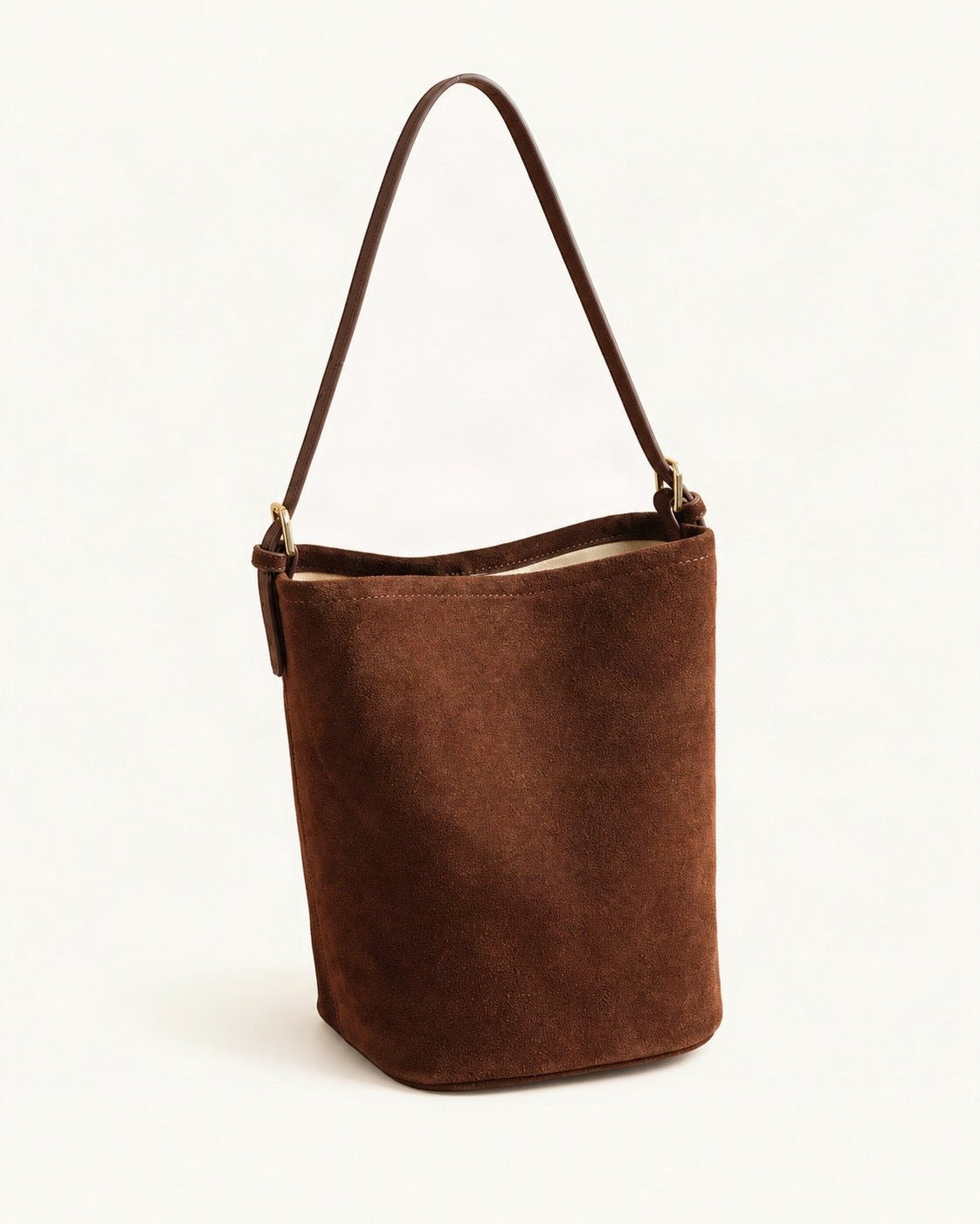 Suede Cowhide Bucket Shoulder Bag — front three-quarter view on a warm white background