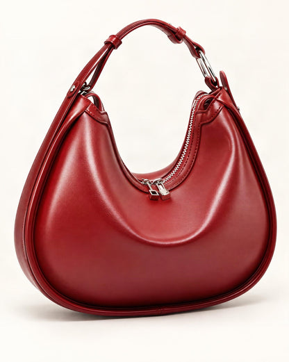 Cowhide Leather Crescent Shoulder Bag — front three-quarter view on a warm white background