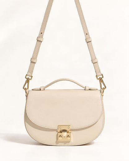 Cowhide Leather Mini Saddle Crossbody Bag with Push Lock — straight-on front view on a warm white background