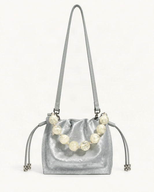 Cowhide Mini Bucket Bag Crossbody Drawstring Bead Handle — straight-on front view on a warm white background