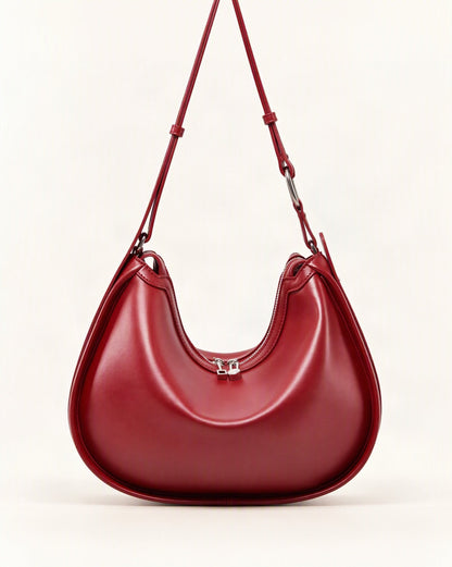 Cowhide Leather Crescent Shoulder Bag — straight-on front view on a warm white background