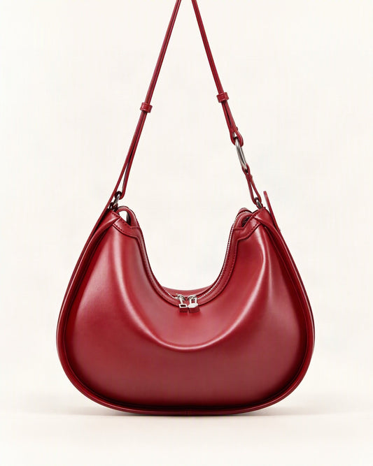 Cowhide Leather Crescent Shoulder Bag — straight-on front view on a warm white background