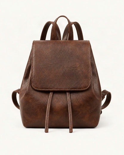 Split Cowhide Mini Backpack — straight-on front view on a warm white background