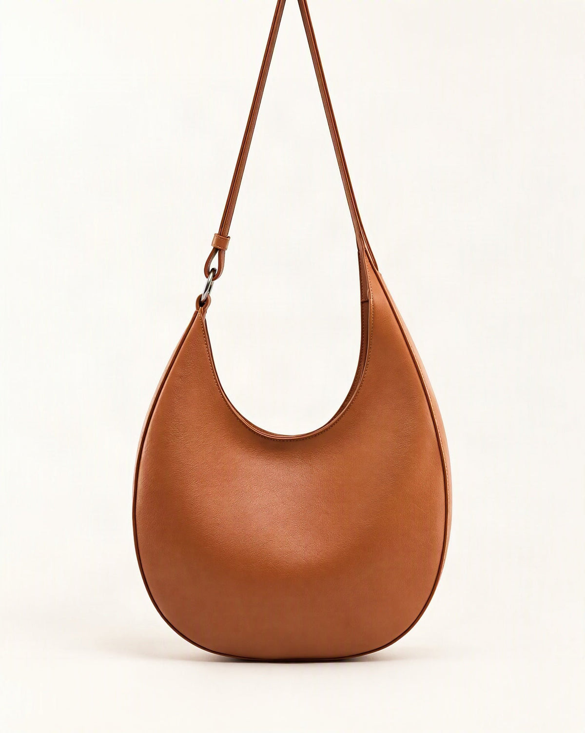 Cowhide Leather Crescent Hobo Bag — straight-on front view on a warm white background