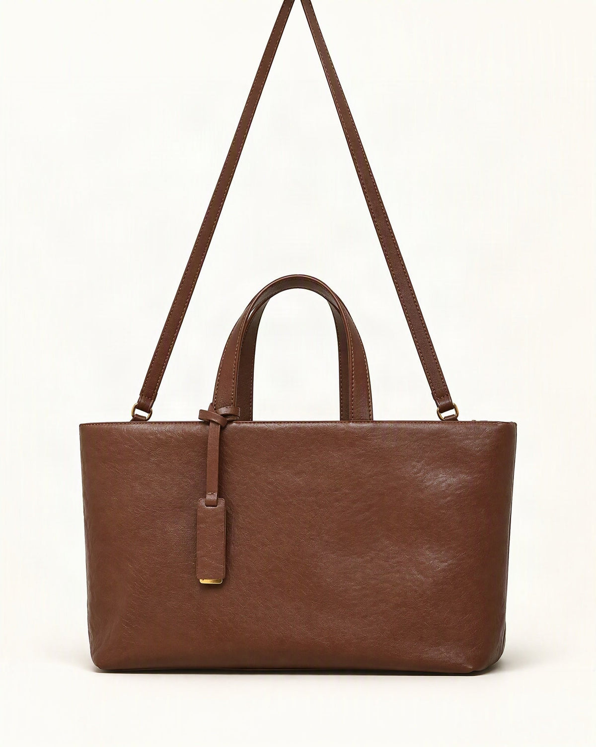 Cowhide Leather Tote Bag with Crossbody Strap — straight-on front view on a warm white background