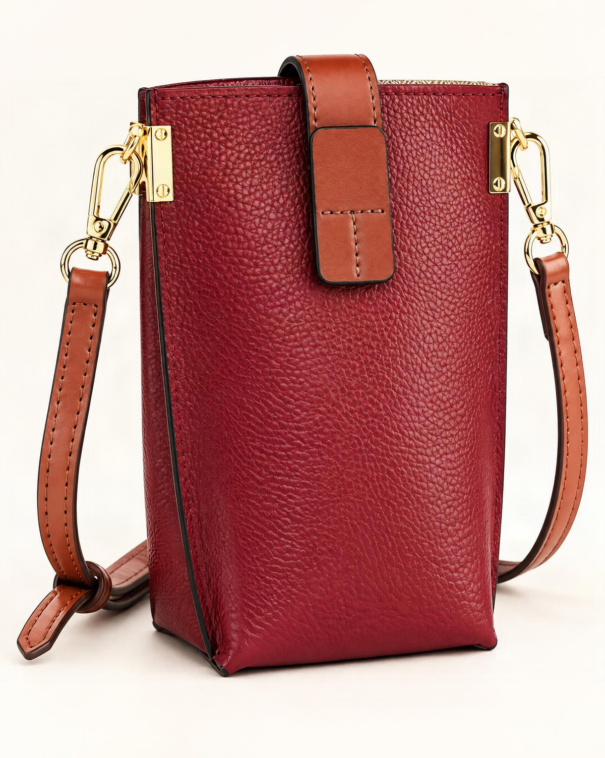 Cowhide Micro Crossbody Phone Bag — front three-quarter view on a warm white background