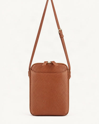 Cowhide Vertical Crossbody Phone Bag, Pebbled — straight-on front view on a warm white background