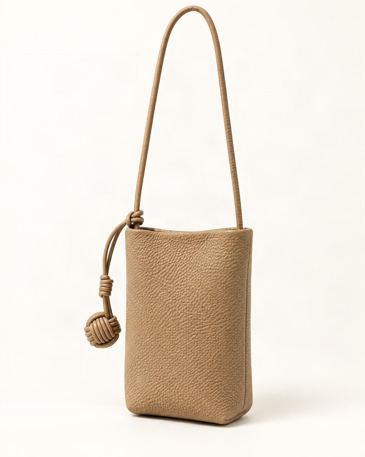 Cowhide Leather Micro Bucket Phone Crossbody Bag — front three-quarter view on a warm white background