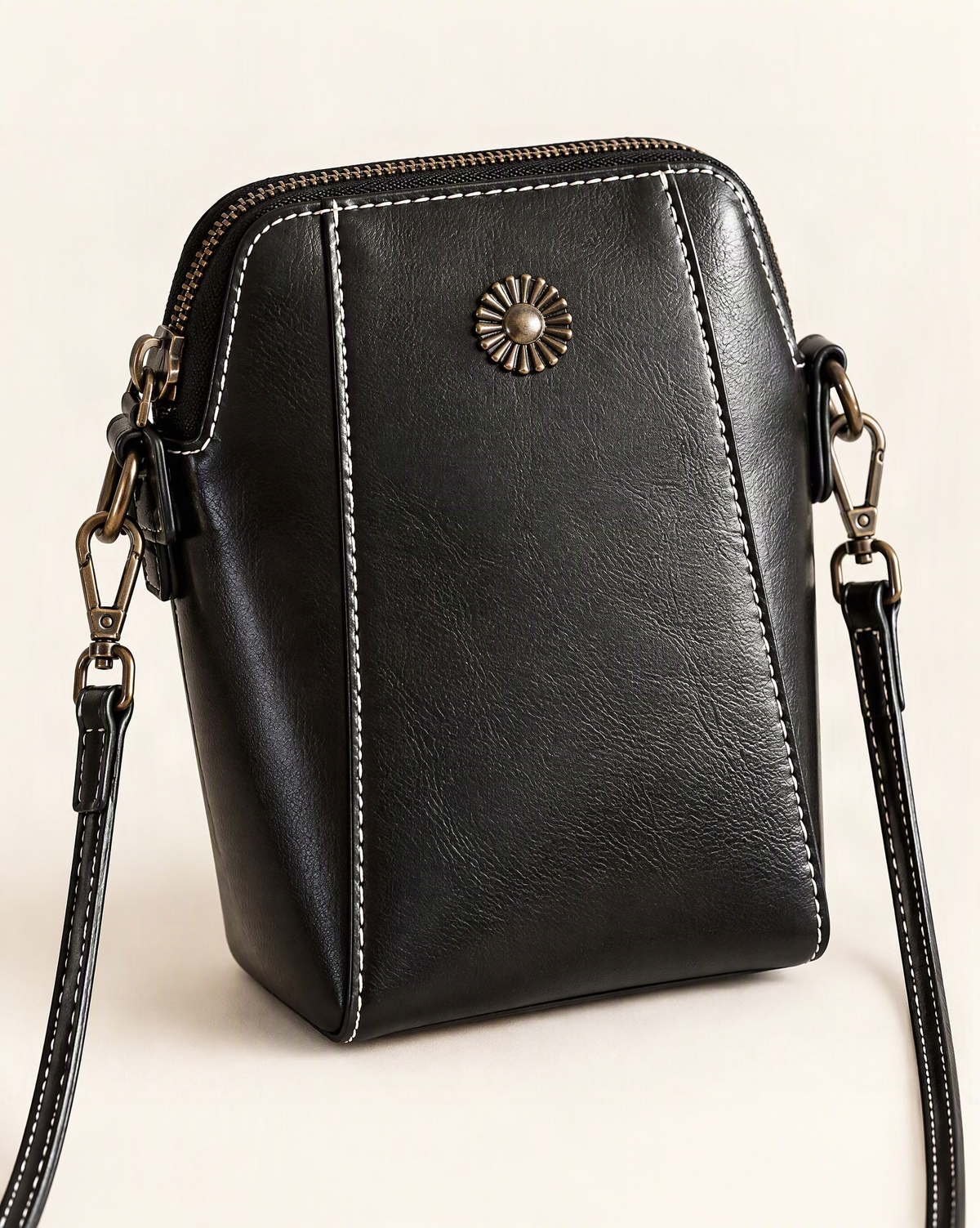Cowhide Leather Micro Crossbody Phone Bag with Zip Closure — front three-quarter view on a warm white background